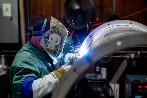 A welding and fabrication employee at US Duct works on a piece of ductwork.